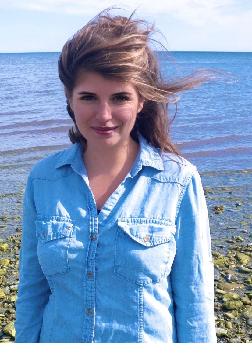 Photo of a woman, Dr. Mary Hamil Gilbert, standing on a beach wearing a blue shirt